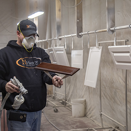 Technician Spraying Cabinet Door