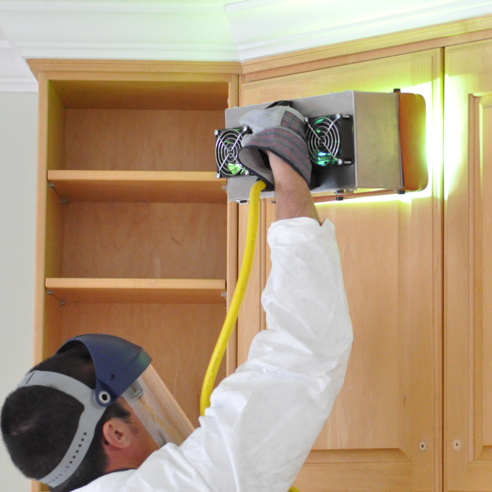 n-hance technician applying UV light to cabinets