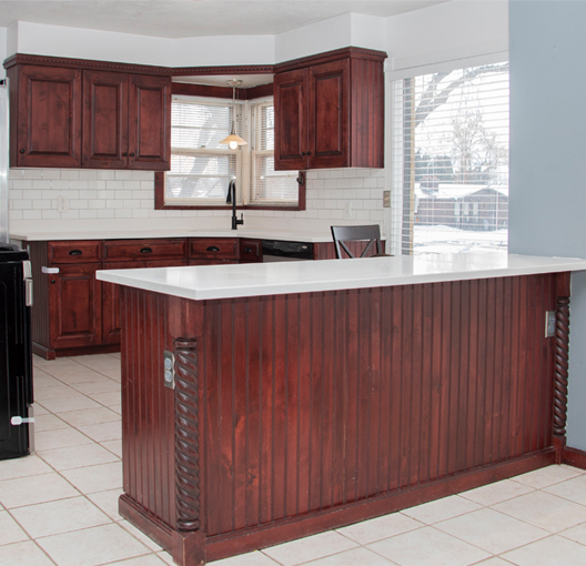 dark wood cabinets in a kitchen before painting