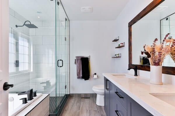 Bathroom with shower, tub, and blue cabinets