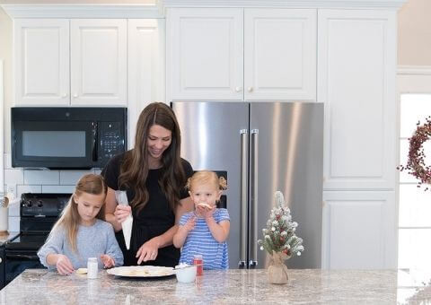 mother and daughters cooking in kitchen