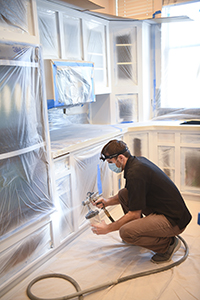 Man painting cabinets