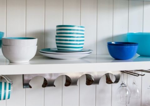 blue dishes on white open shelf cabinets