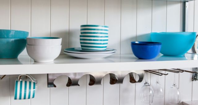 blue dishes on white open shelf cabinets