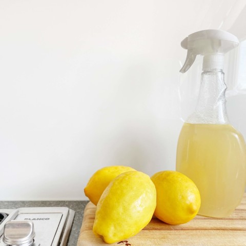 spray bottle with cleaning solution and lemons