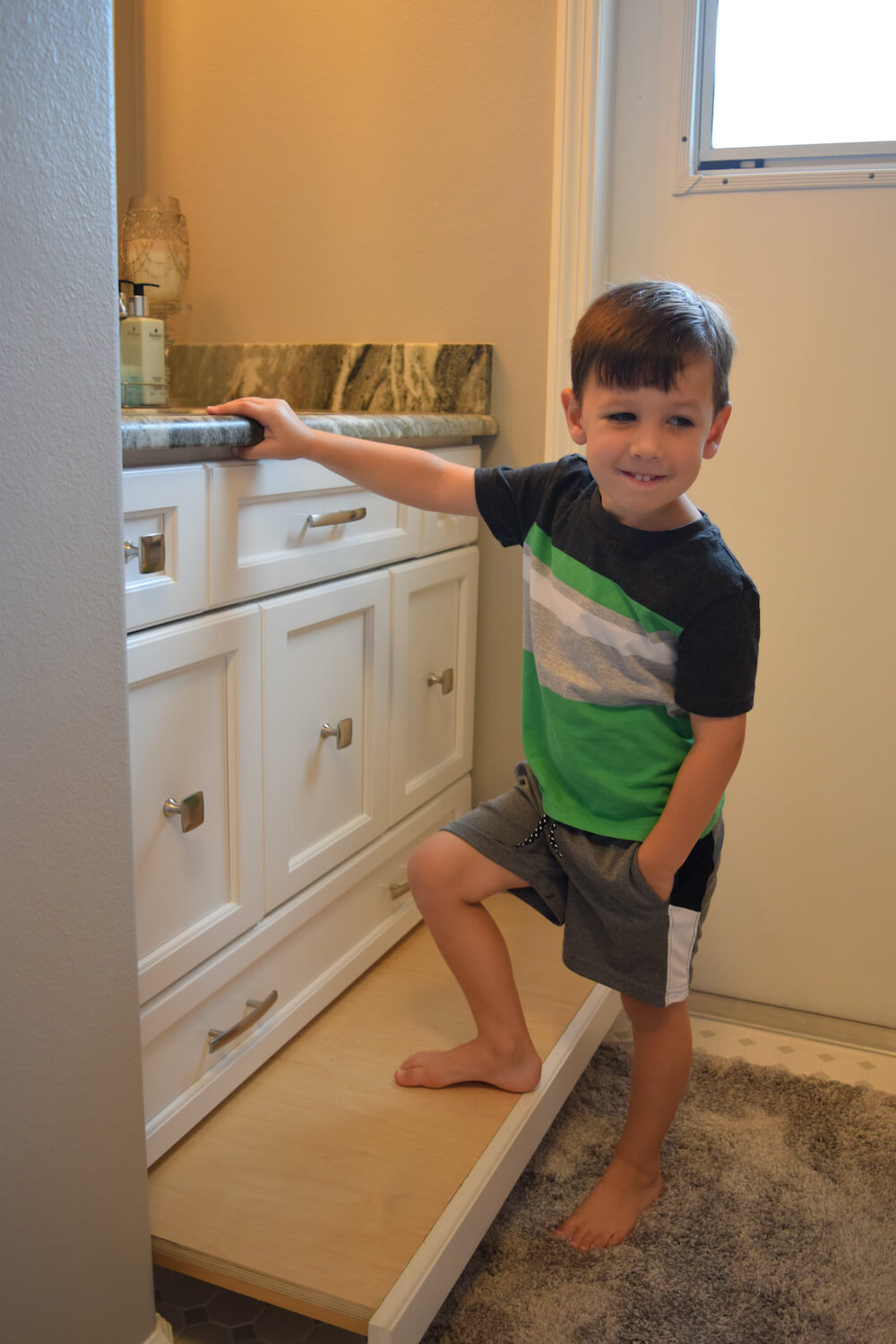 kid next to freshly painted bathroom cabinets in Pontiac