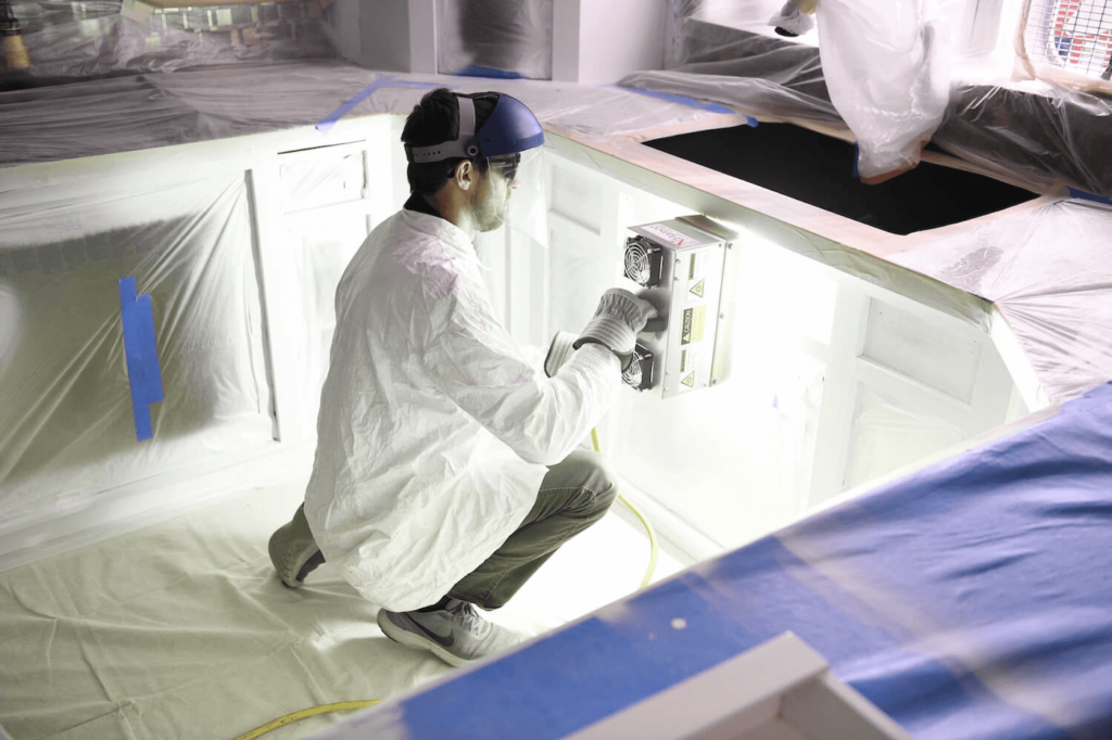 N-Hance team member refacing a cabinet door in a kitchen