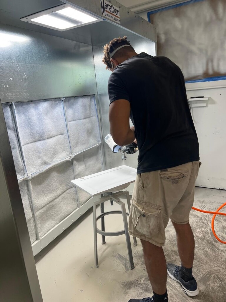 technician painting in spray booth