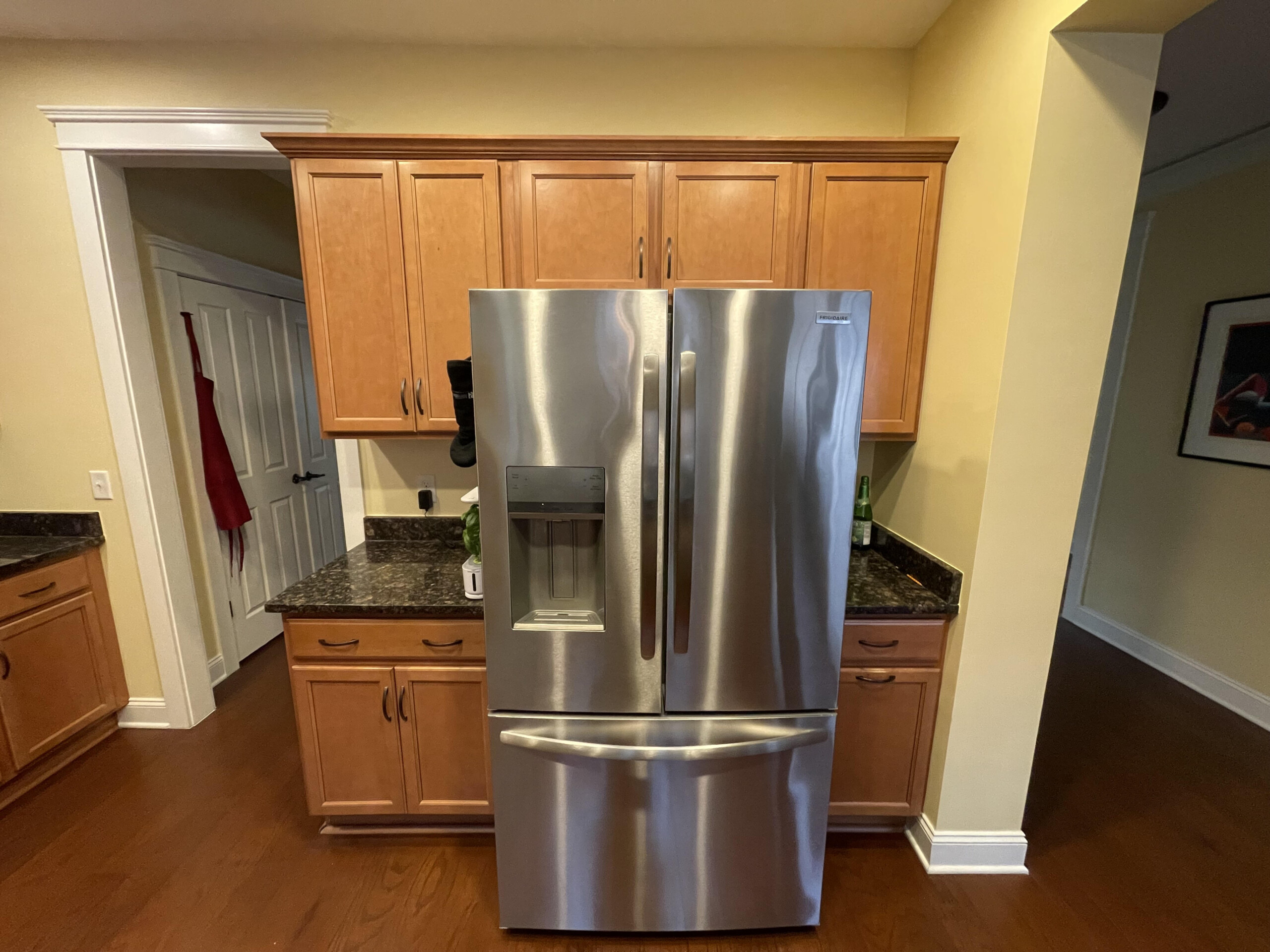 brown kitchen cabinets with a silver fridge