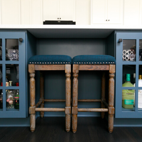 Kitchen island with built in blue cabinets and stools in between