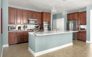 Kitchen with pine colored walls and island with wooden cabinets