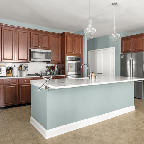 Kitchen with pine colored walls and island with wooden cabinets