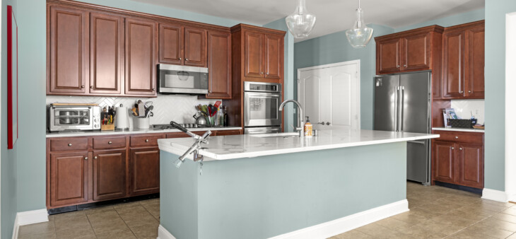 Kitchen with pine colored walls and island with wooden cabinets