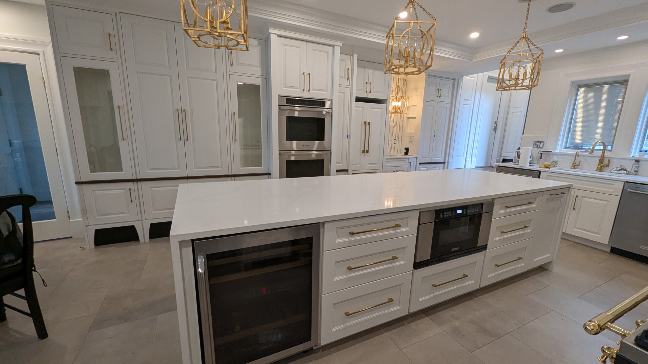 custom white kitchen island with storage, wine cooler and microwave built in