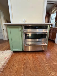 refinished stand alone cabinet. It's green. There is an oven next to the cabinet