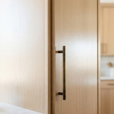 A close-up view of beautifully refinished kitchen cabinets in a modern, brightly lit home.