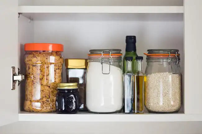 Open cabinet with jars of various food